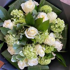 Our Premier One dozen avalanche white roses with assorted greenery